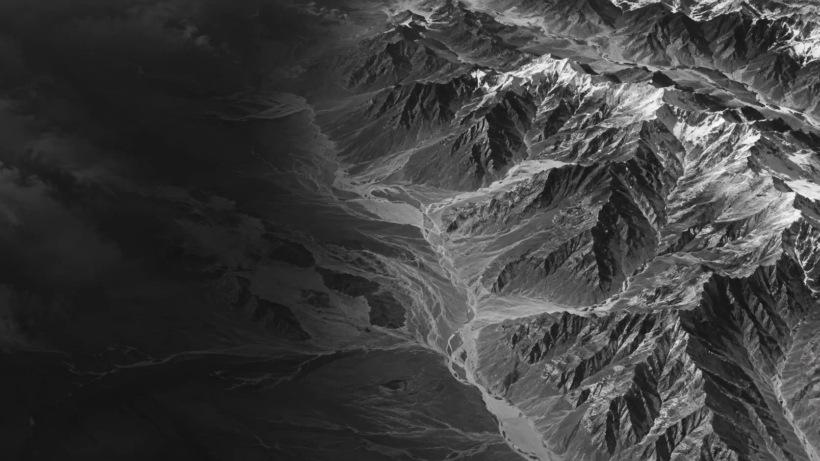 Mountain ridges and branching valleys across a monochrome terrain study